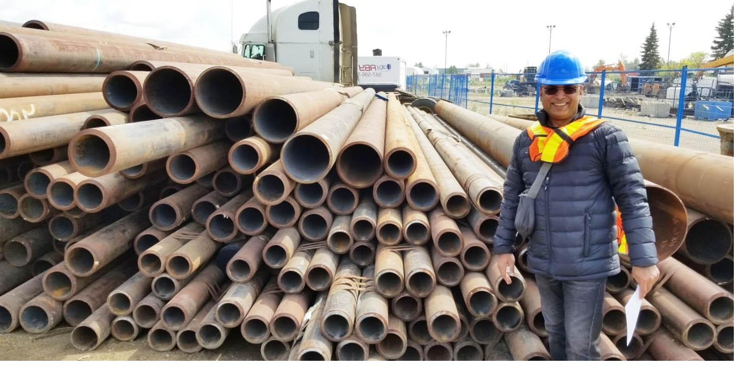 Seamless pipe stacked in a yard, with a member of our team